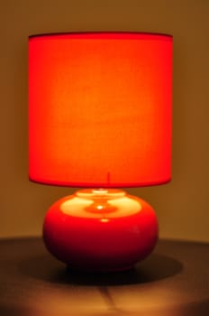 image of a red table lamp sitting on a brown desk