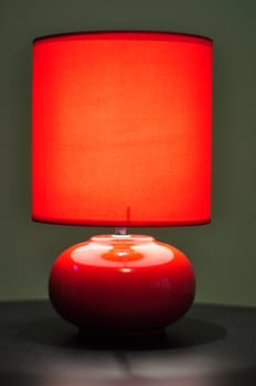 image of a red table lamp sitting on a brown desk