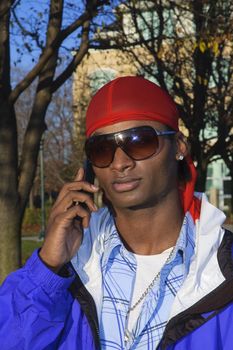 closeup of a young African American man on a cell phone call in an outdoor setting