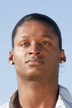 young smiling African American man against a blue sky