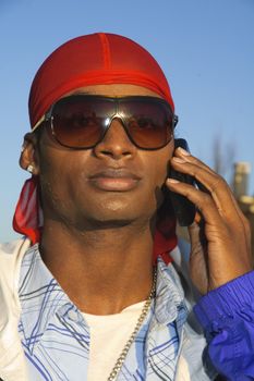 closeup of a young African American man on a cell phone call in an outdoor setting