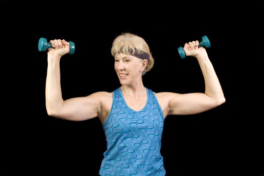 Attractive baby-boomer exercising with weights isolated over black