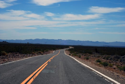 An empty road cuts through the California desert.