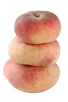 A stack of three flat "Doughnut" peaches, isolated on white with clipping path. Shallow DOF with focus on the center of the upper peach and the side of the lower one.
