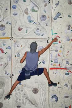 male rock climber inside an indoor rock climbing wall
