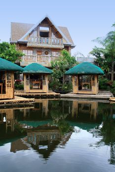 floating nipa huts with reflections on water
