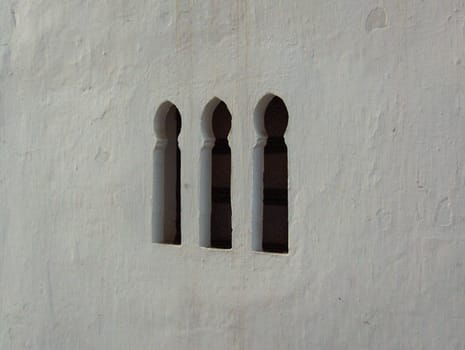 Windows in a white wall in Tangier, Morocco