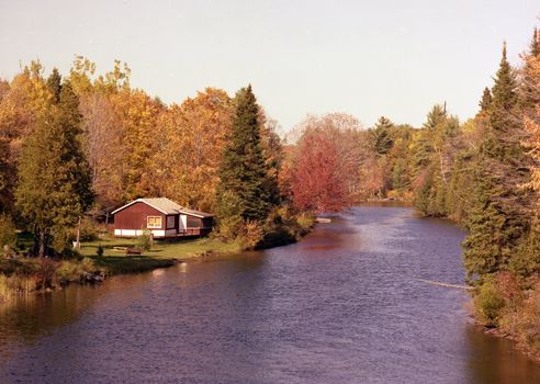 Image of small river and cottage in Haliburton Highlands, Ontario, Canada. It was photographed in the Fall.