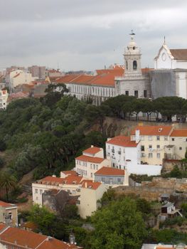 White and pastel homes with terra cotta tile rooves in Lisbon, Portugal