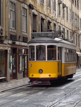 An historic yellow tram in Lisbon, Portugal.