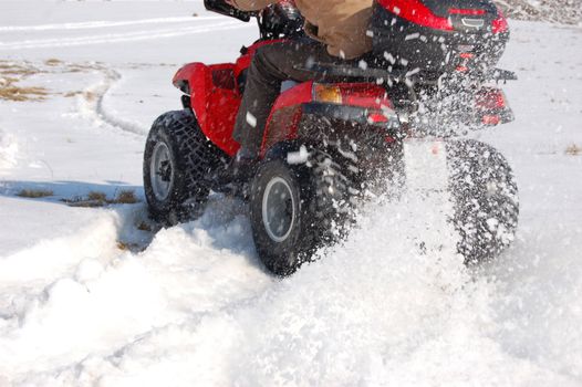 Man riding quad in mountain snow