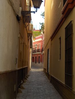 The view down a narrow cobbled street in Seville, Spain.