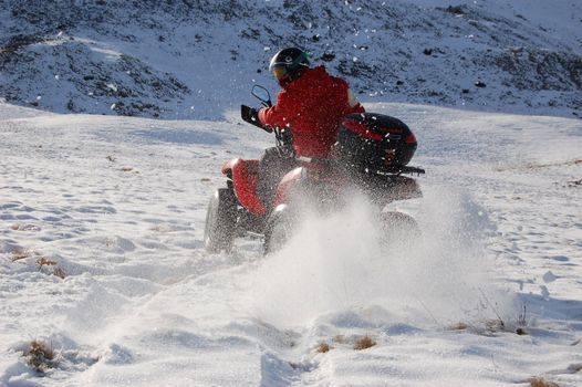 man riding quad in snow