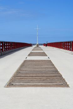 Lonly lady standing at the end of a pier