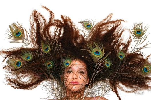 Girl wearing makeup made of rhinestone flowers with peacock feathers in her hair         