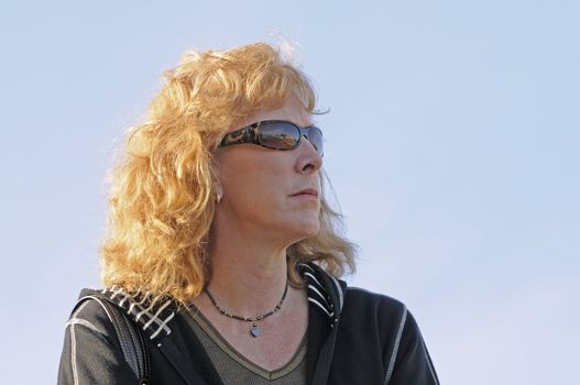Middle-aged woman wearing sunglasses looking off into the distance