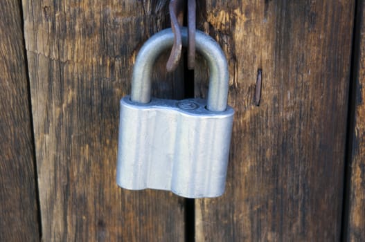 High resolution image. The metal lock hangs on a door.