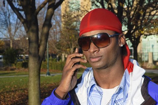 closeup of a young African American man on a cell phone call in an outdoor setting