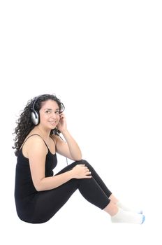 Beautiful young brunette Hispanic woman with headset on listening to music
