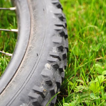 mountain bike offroad tire in green grass showing sport in nature concept