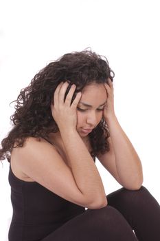 Young Hispanic girl with headache resting head in hands while sitting and isolated on white