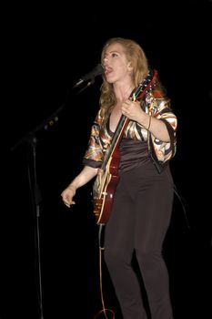 singer/Guitarist playing while isolated on black during live concert