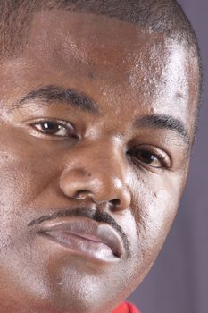 closeup of a young african american man with a pencil mustache