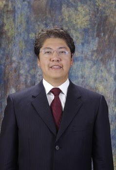 Attractive asian businessman in a suit over a colored background