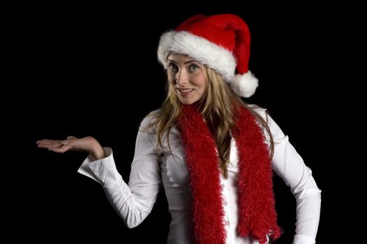 Attractive middle-aged woman in a santa hat and seasonal sweater with an idea and waving a finger over a black background