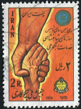IRAN - CIRCA 1976: World Young man holding old man hand, circa 1976.