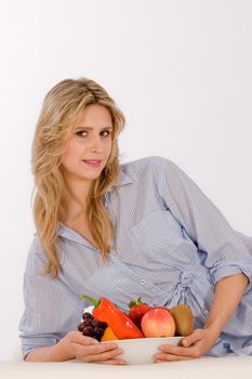 A pretty woman lying in the arm with a fruit bowl