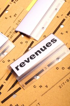 revenue or revenues word on business office folder showing financial success