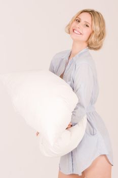 Young smiling girl with pillows and beautiful teeth