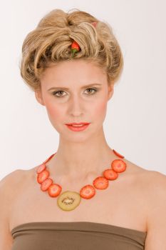 Young woman with a necklace made of strawberries and kiwi