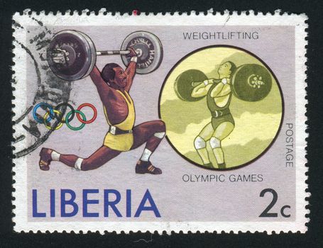 LIBERIA - CIRCA 1976: Weight Lifting and Olympic Rings, circa 1976.