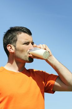 man is drinking fresh glass of milk in the blue skye