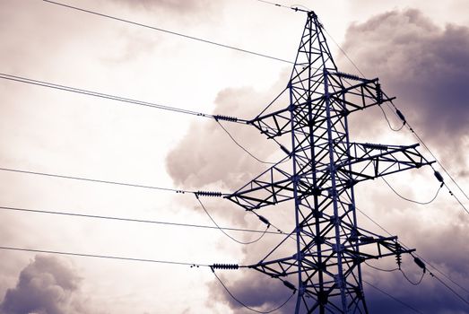 High power electrical pole on a cloudy day with silhouette
