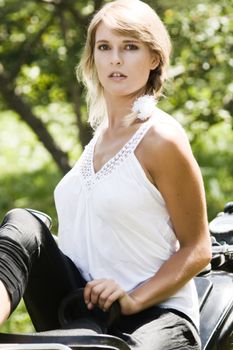 Fashionable young woman on an old motorcycle