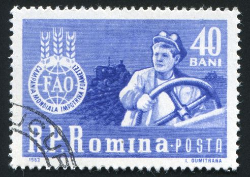 ROMANIA - CIRCA 1963: Tractor Driver and �FAO� Emblem, circa 1963.
