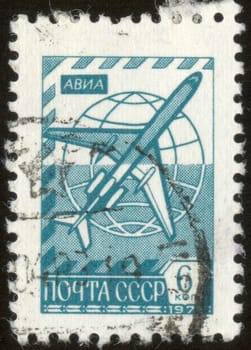 The scanned stamp. The Soviet stamp. The plane flies over the Earth.