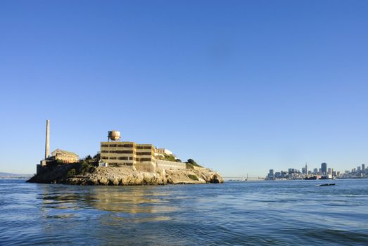 Alcatraz island in San Francisco Bay at sunset from the bay looking towards San Francisco