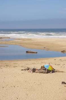 colorful beach umbrella on a deserted Northern California beach with a fog bank just off the coast 