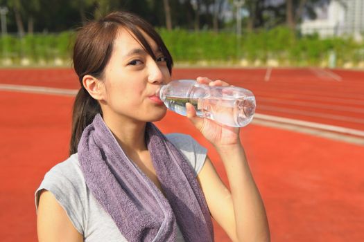 Young woman drinking water at outdoors workout