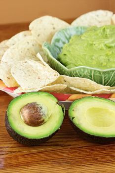 Fresh  avocado with guacamole and tortilla chips in the background. Extreme shallow DOF.