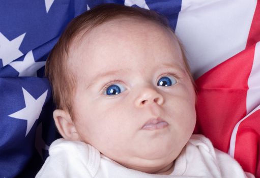 An infant with an American Flag background.