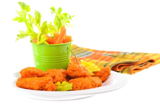 Plate of buffalo style wings with crisp vegetables.