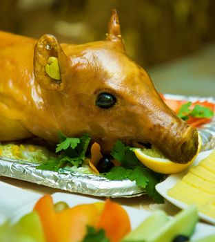 roast suckling pig on the decorated table in the restaurant
