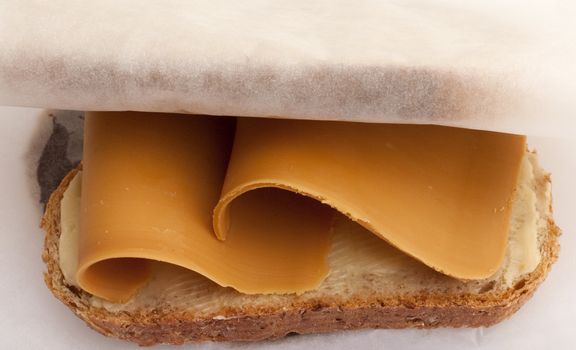 Traditional Norwegian lunch: sliced bread with brown cheese wrapped in paper