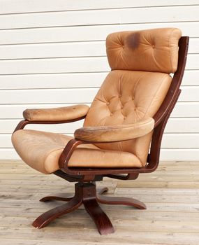 Old worn and dirty brown leather recliner chair