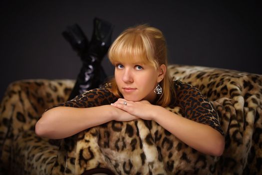 Young beautiful girl lying on the sofa - Leopard theme on black background